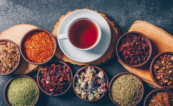 Set of wood stubs and a cup of tea and tea herbs in a bowls on a